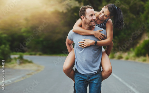Love, piggyback or happy couple walking on road or outdoor date for care, support or loyalty. Freedom, romantic man or woman on holiday vacation together to relax or smile on street for wellness