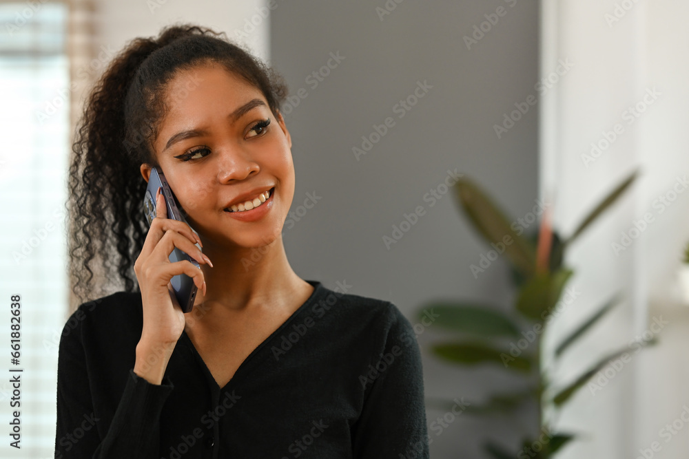 Happy smiling African black teenage woman with curly hair having a nice conversation on the phone Happy smiling African black teenage woman with curly hair having a nice conversation on the phone