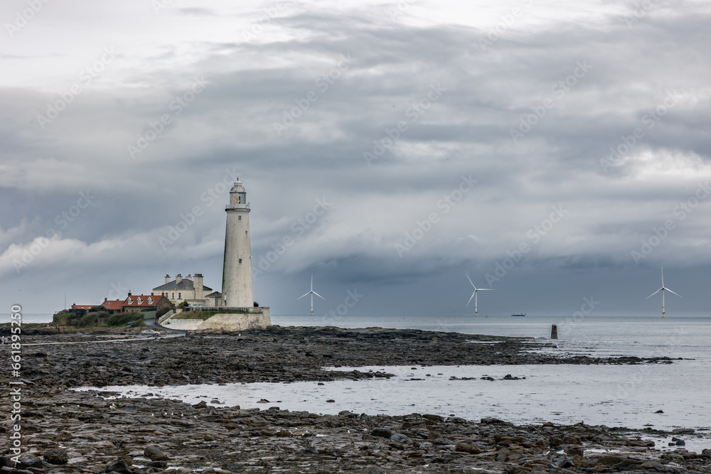 St. Mary's Lighthouse with three large offshore windmills, turbines for alternative green, renewable energy, electricity, just of the English coast. Whitley Bay, Newcastle, UK
