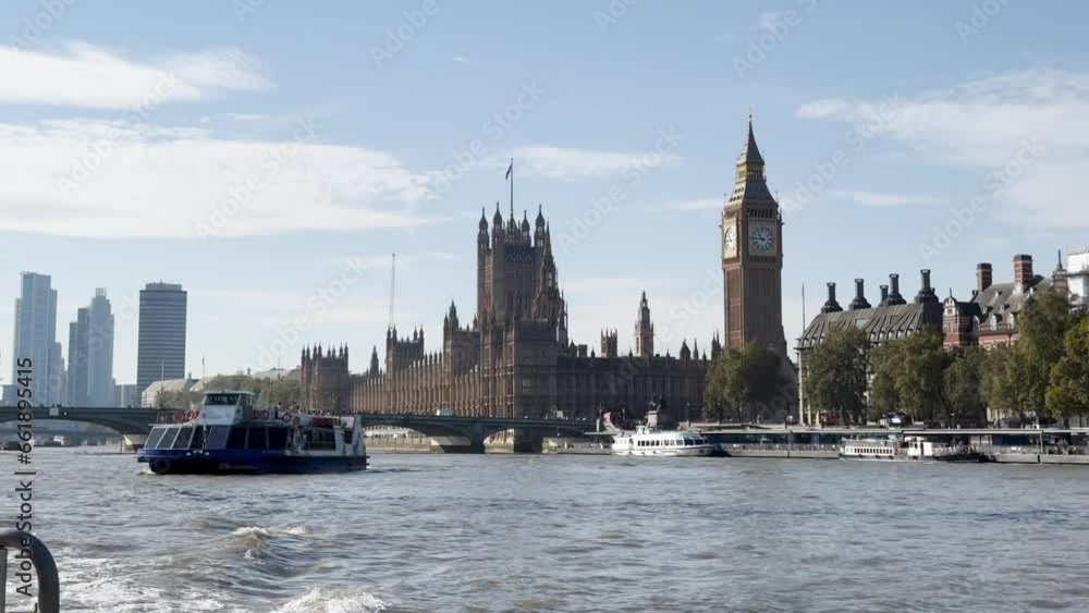 A daytime exterior establishing shot of the iconic London skyline as seen from the River Thames. Big Ben and the Clock Tower in the distance.  	
