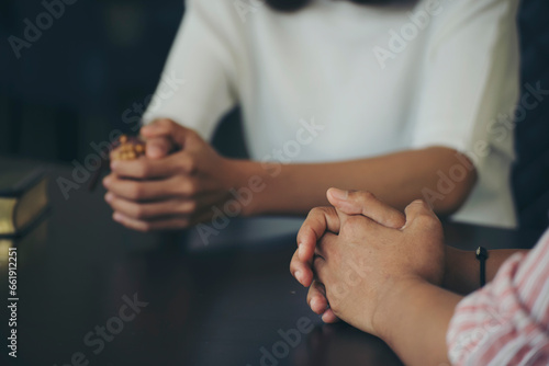 group of Asian and Diversity people Catholic pray and hope for peace the world and free from war. Young man and woman Hand in hand together (worship christian), thinking and closed eyes at church.
