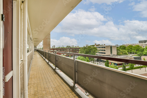 a balcony with some buildings in the background and blue sky above it  as seen from an apartment building s balcony