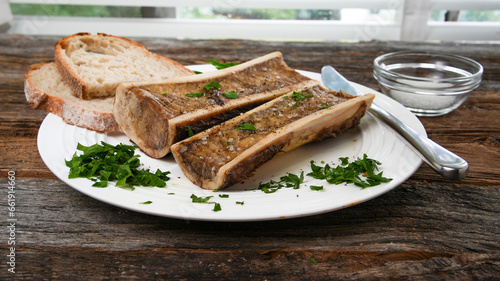 Roasted marrow bones on rustic wood near window