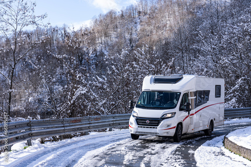 Campervan on a snowy road in Italy © ivoderooij