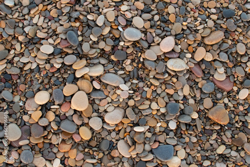 Pebbles of different colors on the beach in the port of Sagunto, Spain. Amazing pebbles background. Pebbles texture.