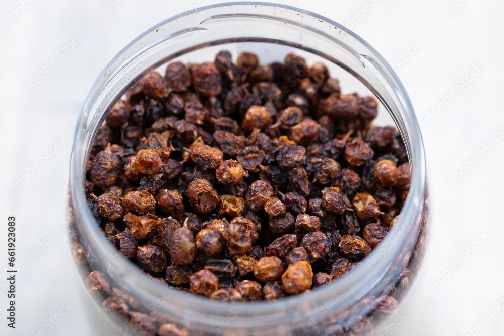 A close up portrait of a plastic jar or pot full of fresh dried loose buckthorn tea in it. The herb is ready to be used in a relaxing cup of the warm beverage or drink for some zen time. A close up portrait of a plastic jar or pot full of fresh dried loose buckthorn tea in it. The herb is ready to be used in a relaxing cup of the warm beverage or drink for some zen time.
