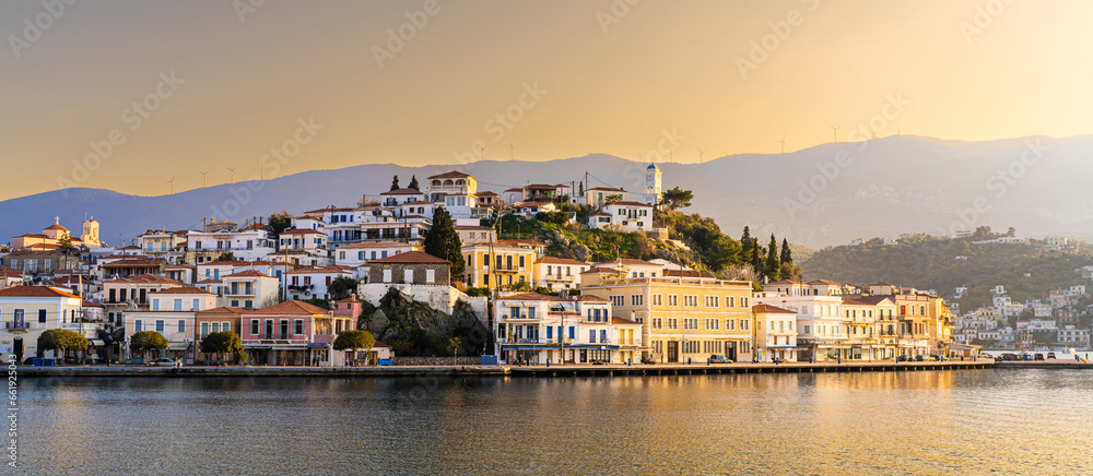 Naklejka premium Poros, Greece - 17 February 2023 - View on the town of Poros on Poros island seen from the mainland at sunset