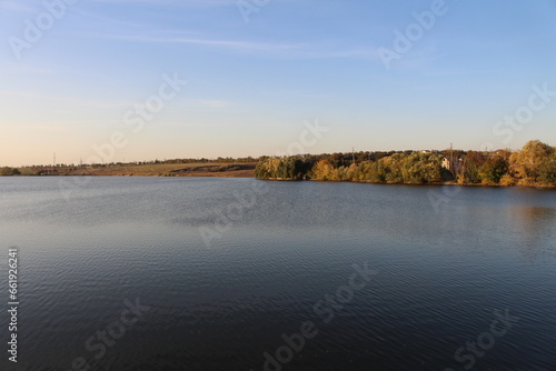 A body of water with trees and a hill in the background