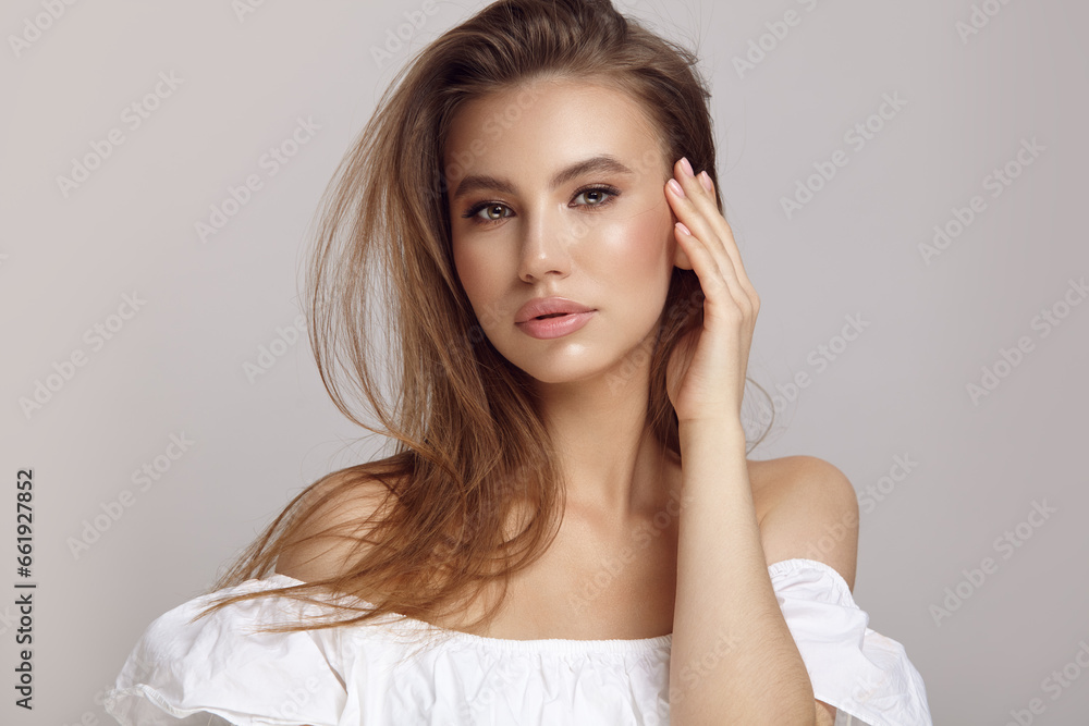 Seductive woman touches cheek looking at camera in studio Seductive woman touches cheek looking at camera in studio