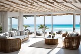 A beach house living room with white-washed walls, rattan furniture, and a view of the ocean.