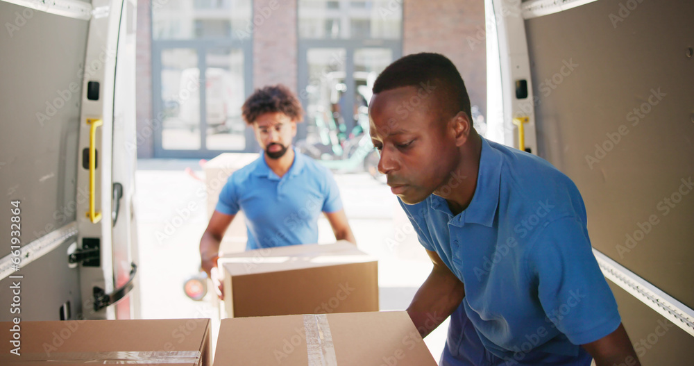 Young Delivery Men Loading Cardboard Boxes Young Delivery Men Loading Cardboard Boxes