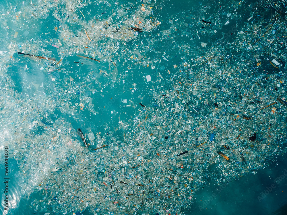 Ocean and plastic trash in Bali island. Aerial view of pollution by plastic rubbish in marina