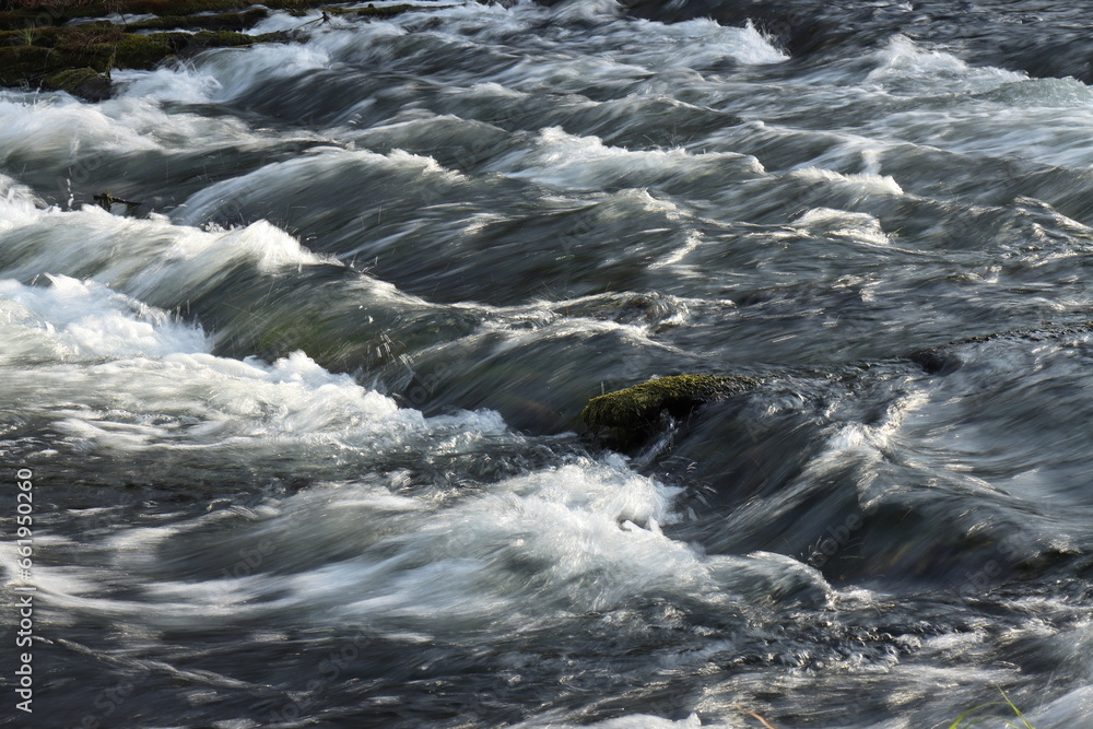 Raging flow of water through the sunken logs of a destroyed dam Raging flow of water through the sunken logs of a destroyed dam