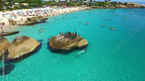 Sea, beach and drone of crowd on holiday, tropical vacation or summer travel outdoor in Cape Town South Africa. Ocean, aerial view and people in water, seascape and rock for tourism or swim in nature