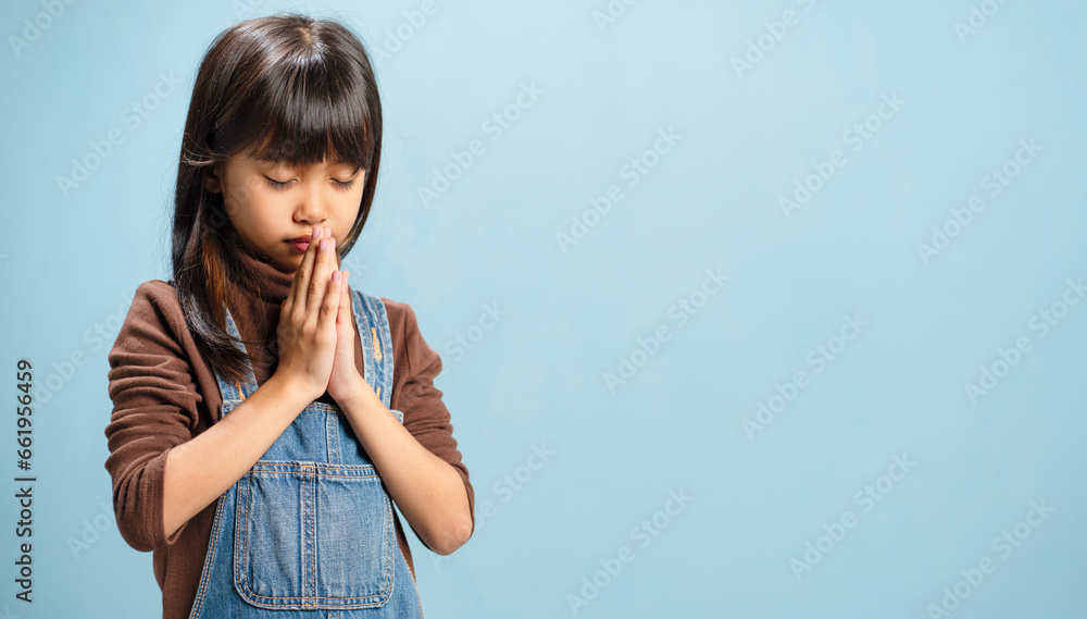 A little girls is putting their hands together to pray for God's blessings. A little girls is putting their hands together to pray for God's blessings.