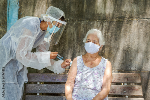 Mulher idosa recebe vacina contra covid em área rural de Guatani, estado de Minas Gerais, Brasil. photo
