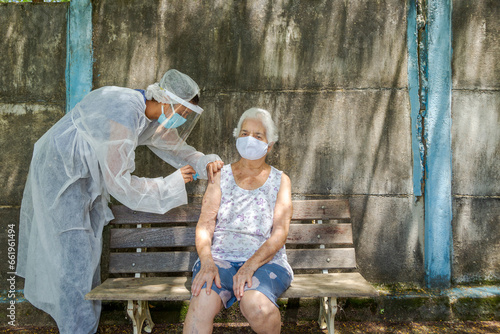 Mulher idosa recebe vacina contra covid em área rural de Guatani, estado de Minas Gerais, Brasil.