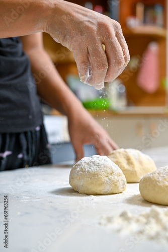 baker kneading dough on table