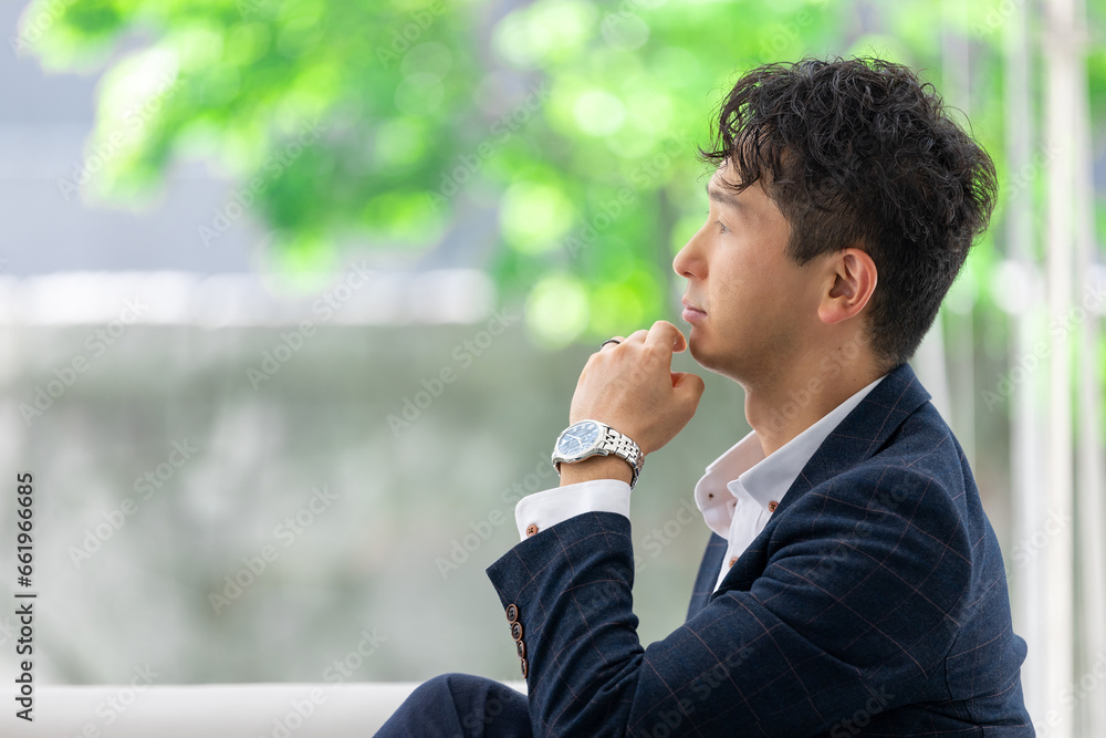 考え事をする男性ビジネスマン