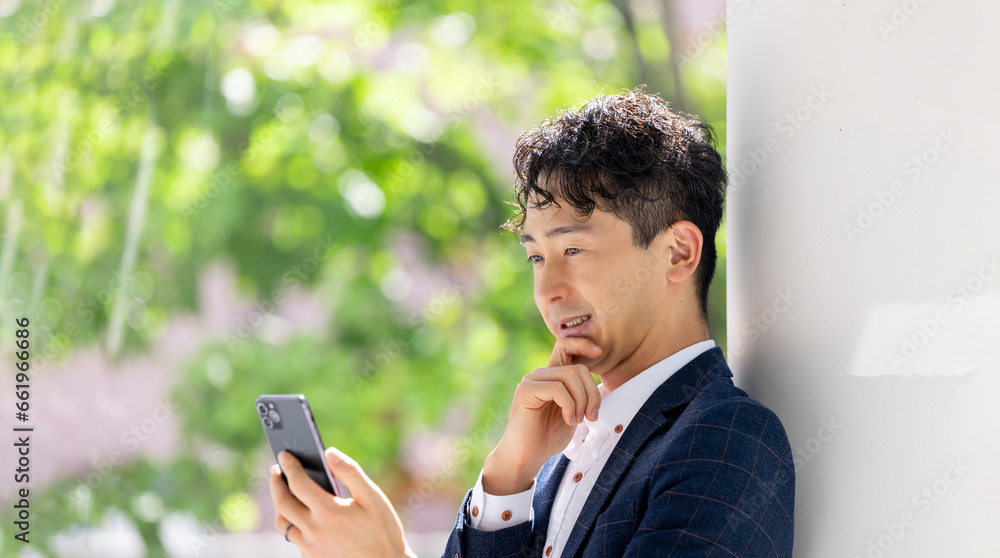 スマホを見る笑顔の男性ビジネスマン