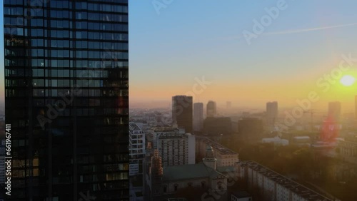 Modern business districtcity glass skyscrapers drone zoom in close to the buildings. Skyscraper in the big city top view during the sunrise when first sun rays are going through the glass windows. photo