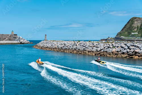 Two jet skis sailing down the Urola river towards the Cantabrian Sea on a sunny day, Zumaia, Gipuzkoa, Basque Country, Spain, Europe