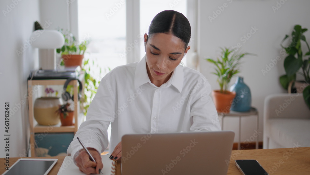 Student girl writing notes learning online home closeup. Woman watching laptop Student girl writing notes learning online home closeup. Woman watching laptop