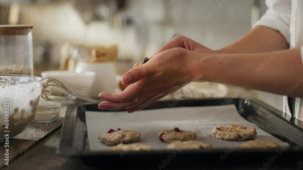 Ingredients. Young mother in kitchen clothes happily preparing dough for baking cookies in the kitchen. Close up of modern woman putting dough on oven tray using kitchen utensils, thanksgiving day Ingredients. Young mother in kitchen clothes happily preparing dough for baking cookies in the kitchen. Close up of modern woman putting dough on oven tray using kitchen utensils, thanksgiving day