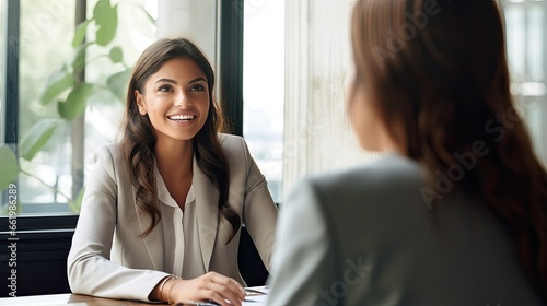 A young business woman is interviewing a job applicant. Colleagues are discussing something. Business, career and placement concept. Illustration for brochure, advertising, marketing or presentation.