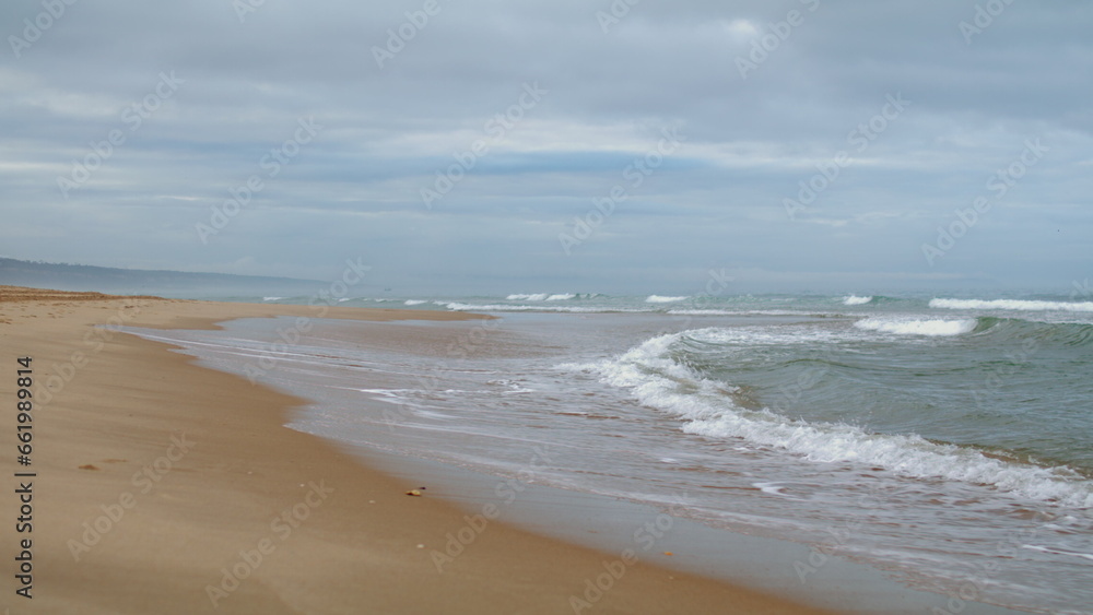 Waves washing ocean shore on gloomy day. Peaceful zen like spot for meditation.