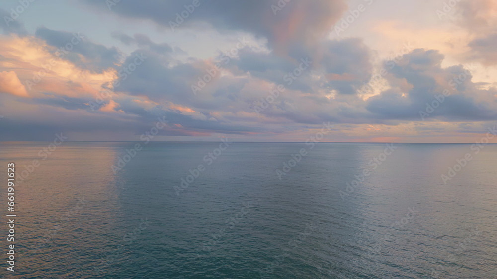 Breathtaking ocean sunrise panoramic drone view. Sunlight shining through clouds