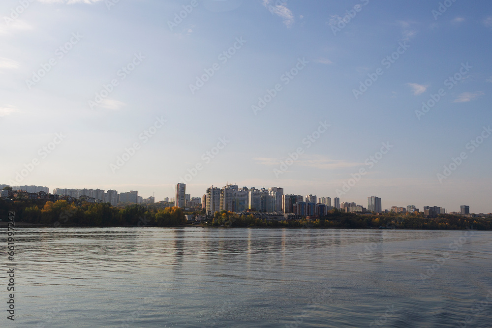 city skyline. Building and skyscraper nearby the river. landscape of a big river with steep banks. clouds over the blue river. dawn over the lake