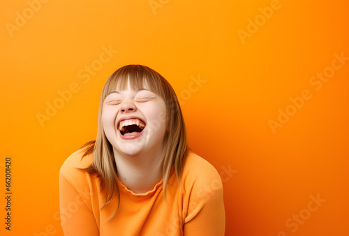 Portrait of a happy girl/woman with down syndrome on an orange background