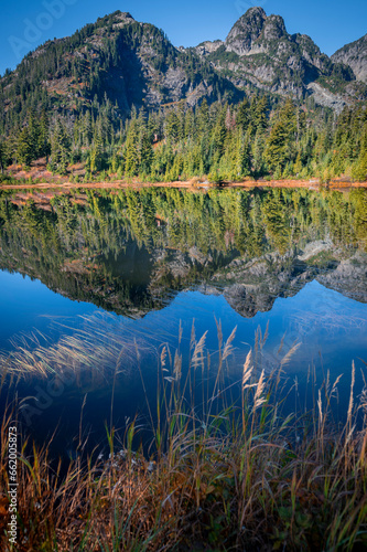 Cascade Mountains reflected in the still waters of Picture Lake in the Mt. Baker Forest. Fall colors add to the beauty of this alpine environment in the area known as Heather Meadows Washington state.