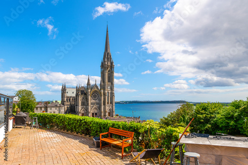 View of Saint Colman's Cathedral from a terrace overlooking the city and harbor in the Cobh, County Cork, Ireland. photo