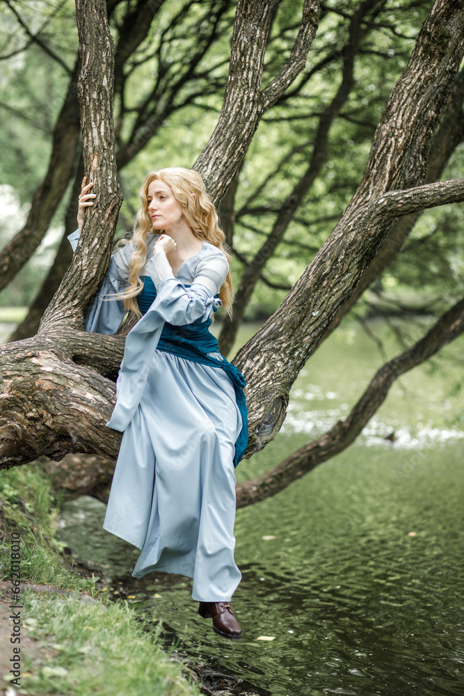 A young beautiful girl in a summer park. A beautiful medieval elf princess in a blue dress in the forest. A young beautiful girl in a summer park. A beautiful medieval elf princess in a blue dress in the forest.
