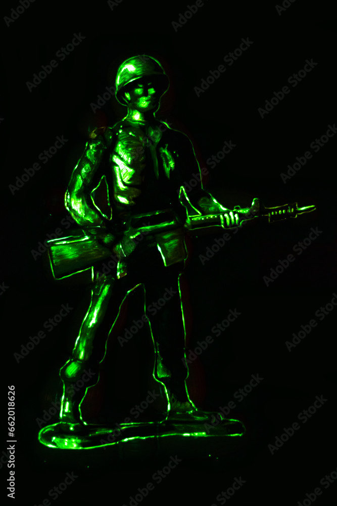 illuminated green army man glowing on black background
