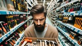 Close-up photo of a man with a beard thoughtfully perusing a selection of hand tools, such as hammers and screwdrivers.