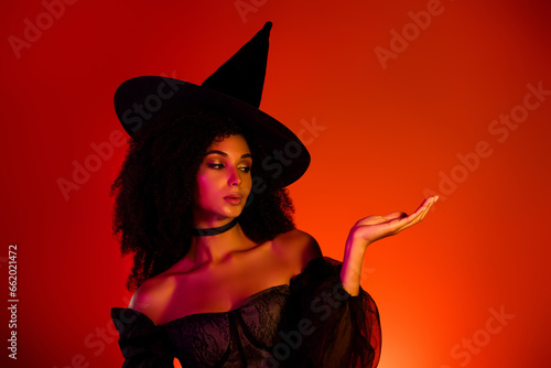 Photo of powerful witch lady enchanted doing ritual spell demonstrate halloween theme event offer on red background