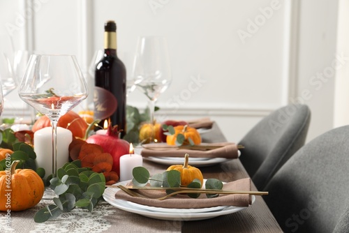 Beautiful autumn table setting. Plates  cutlery  glasses  pumpkins and floral decor