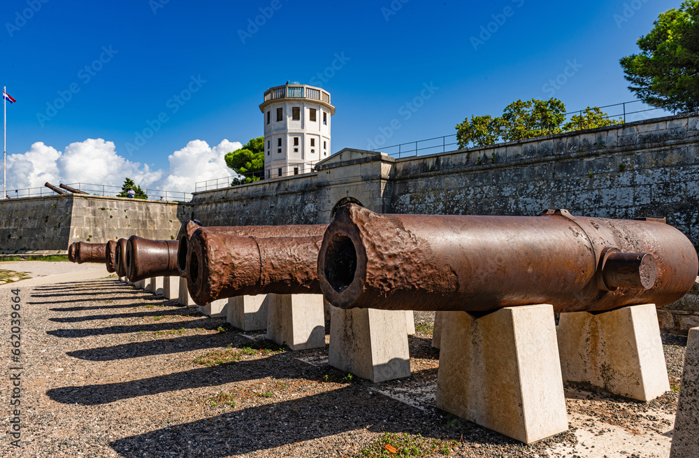 Medieval cannon barrels in front of Pula citadel, an artillery fortress with observation tower, Croatia, Europe.