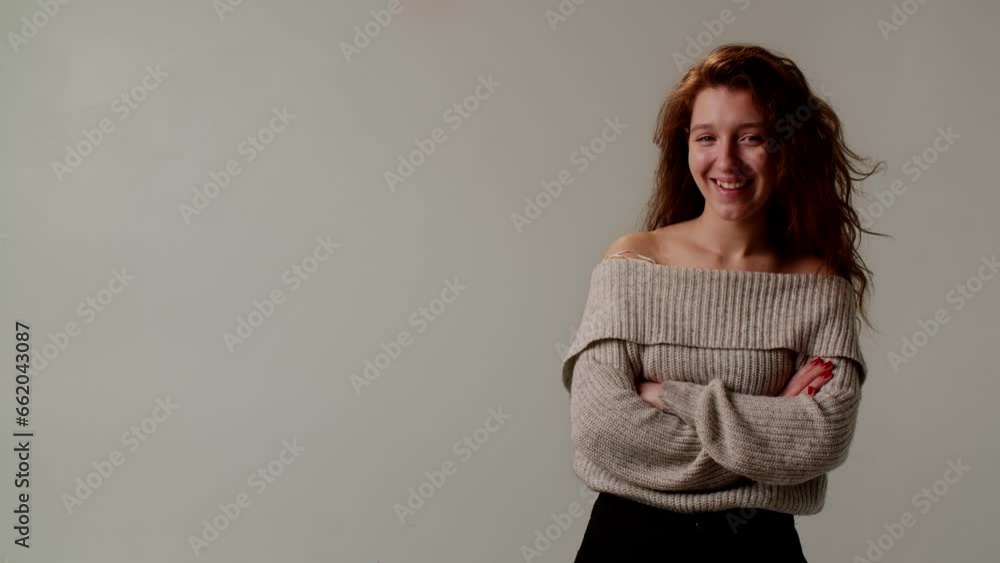 A positive young lady smiles, looks at the provocateur condescendingly and shakes head ironically. A cute girl laughs playfully after funny joke or anecdote. Demonstration of a closed pose with arms A positive young lady smiles, looks at the provocateur condescendingly and shakes head ironically. A cute girl laughs playfully after funny joke or anecdote. Demonstration of a closed pose with arms