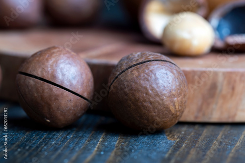 Unpeeled macadamia nuts on a wooden table