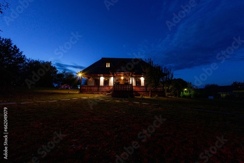 traditional wooden house at night on hill 