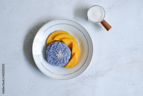 Top view of a plate of mango sticky rice in white background 