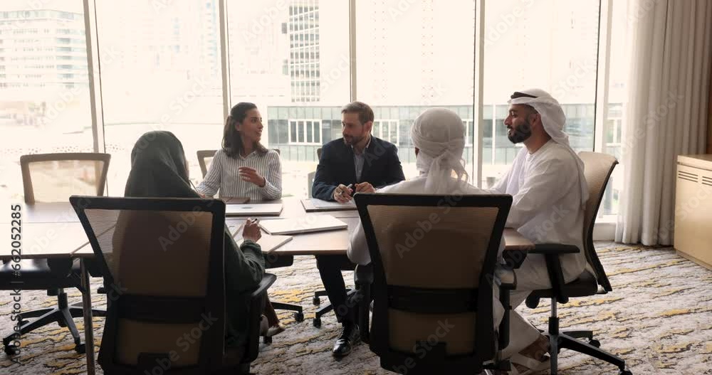In modern conference room group of young and middle-aged multicultural teammates take part in formal meeting in office. Corporate briefing or negotiations event of diverse multinational businesspeople In modern conference room group of young and middle-aged multicultural teammates take part in formal meeting in office. Corporate briefing or negotiations event of diverse multinational businesspeople