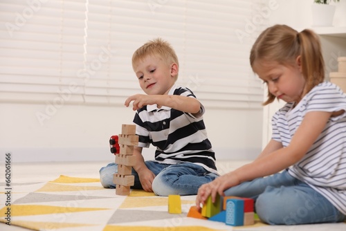 Little children playing with building blocks indoors. Wooden toys