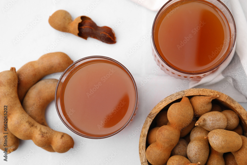 Tamarind juice and fresh fruits on white table, flat lay Tamarind juice and fresh fruits on white table, flat lay