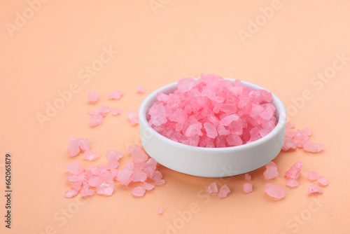 Plate with pink sea salt on beige background, space for text