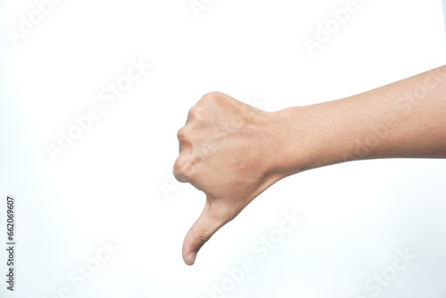 Arm and hand of asian young man over white isolated background doing thumbs down rejection gesture, disapproval dislike and negative sign photo